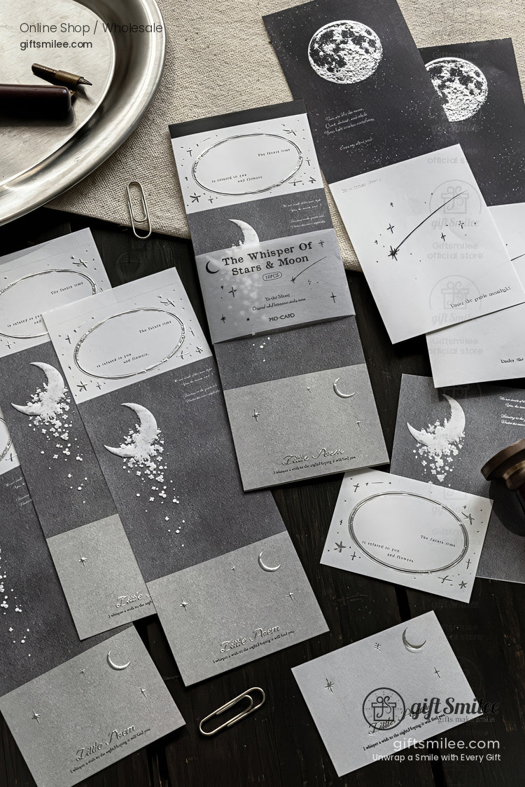 Moon and stars themed grey stationery set with celestial illustrations displayed on a dark desk, ideal for gift notes or journaling.