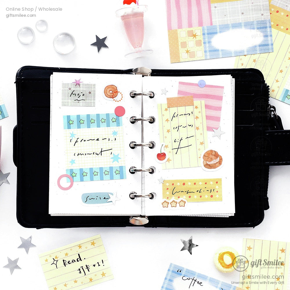 Open black leather planner with colorful pastel sticky notes handwritten text star stickers and a playful drink charm