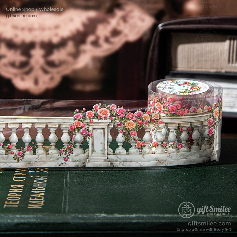 Decorative floral washi tape rolls with balcony and trellis designs displayed on an open vintage book for scrapbooking and journaling.