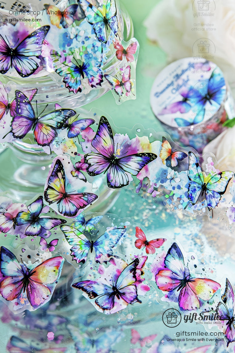 Holographic watercolor butterfly stickers in pastel rainbow colors on a teal background – decorative planner and scrapbooking decals.