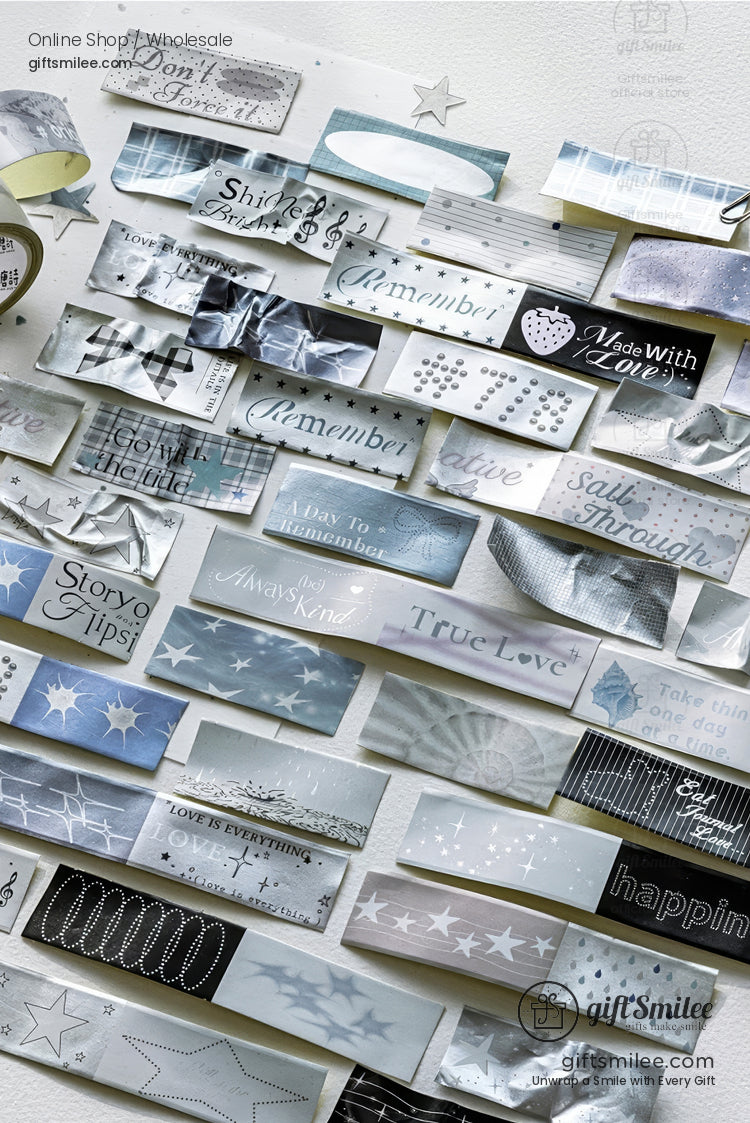 Silver and grey decorative washi tapes with inspirational words and star patterns displayed flat lay for scrapbooking and gift wrapping.