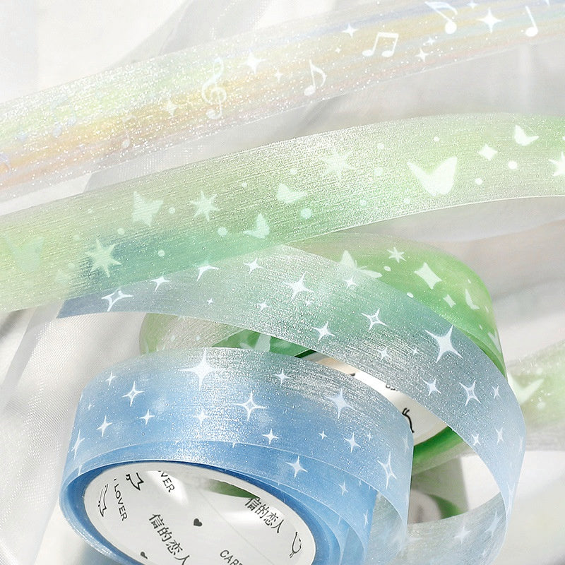 Pastel blue and green washi tapes with glittery star butterfly and music note patterns on translucent material