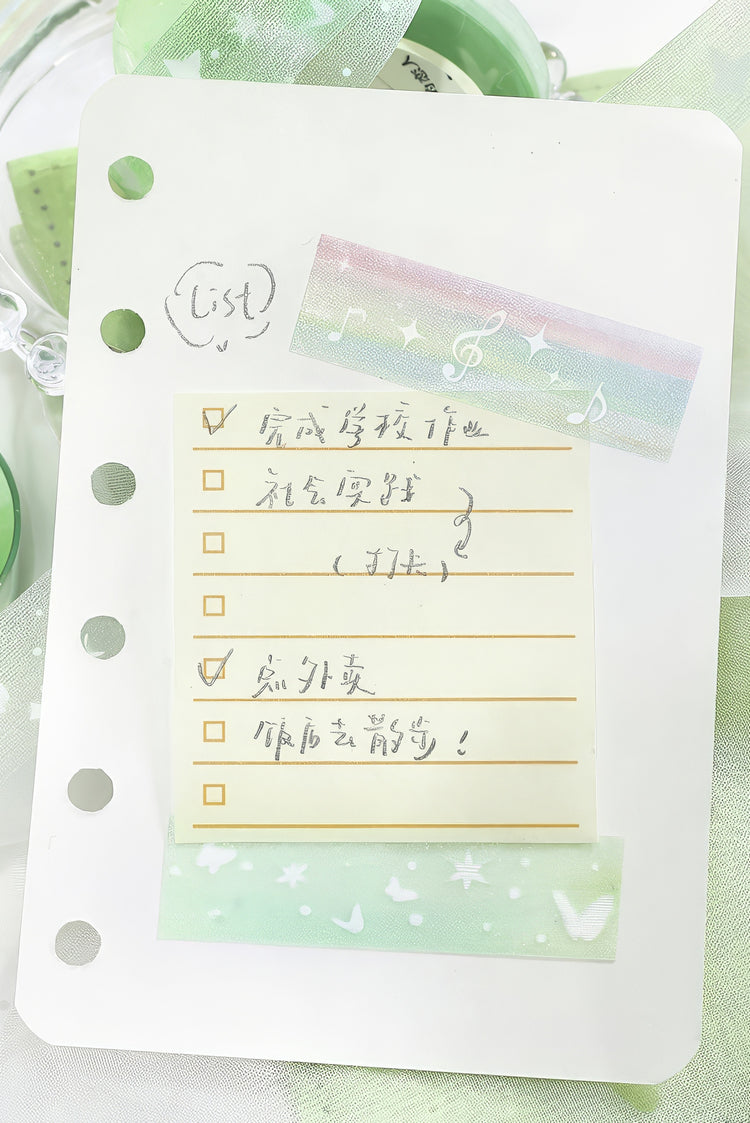White perforated notepad with handwritten checklist pastel rainbow tape with music notes and green butterflypatterned tape