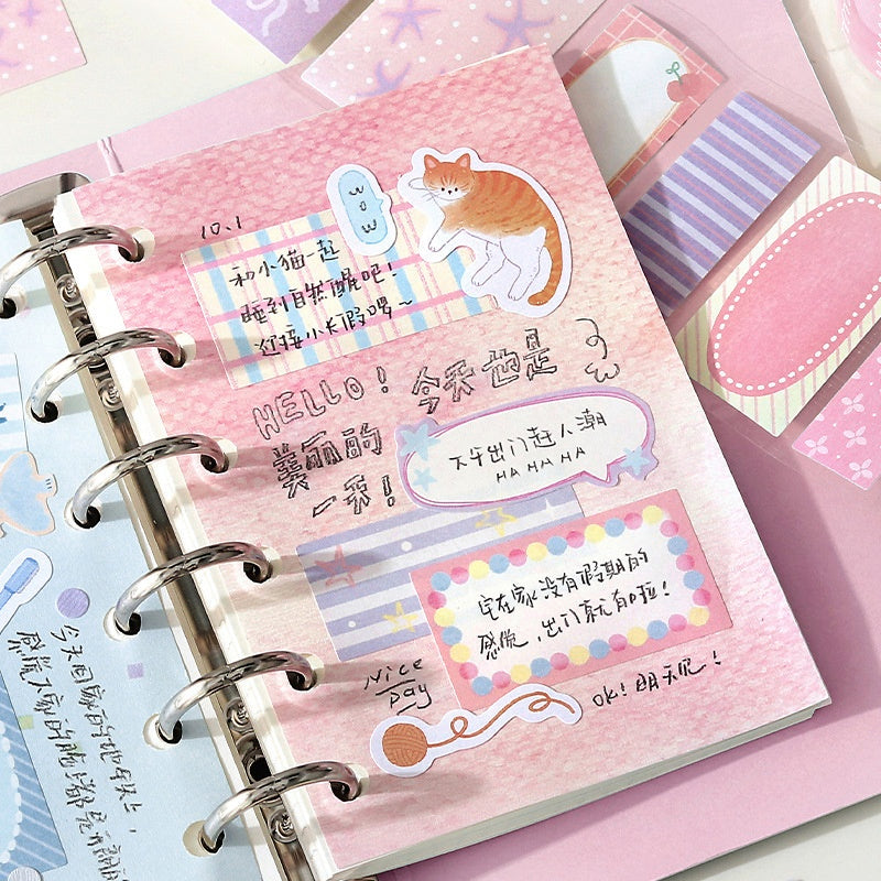 Pink spiralbound planner with handwritten notes colorful stickers striped patterns and a playful orange cat decal
