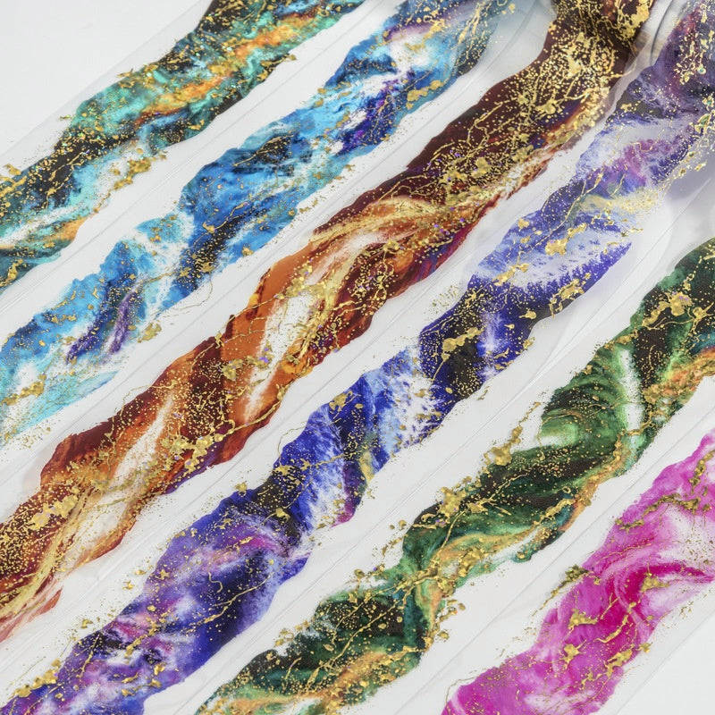 Metallic foil nail art strips with marbled swirls in blue green pink and gold accents on clear backing