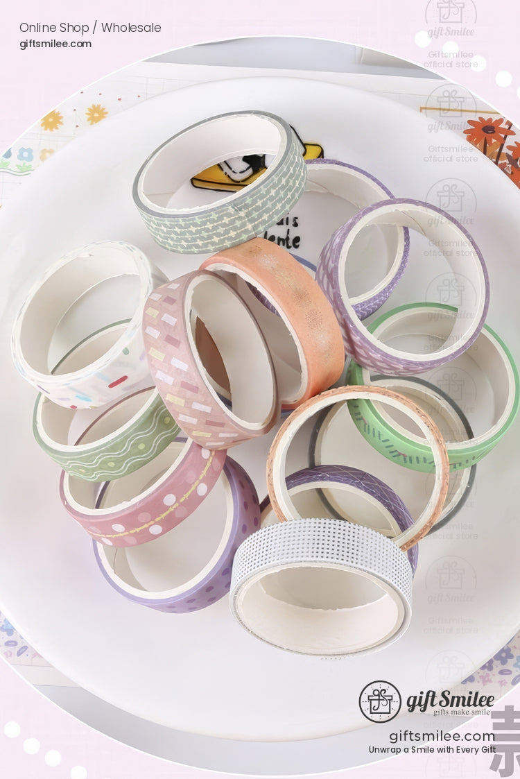 Pastelcolored decorative washi tape rolls with patterns like stripes dots and grids arranged on a white plate