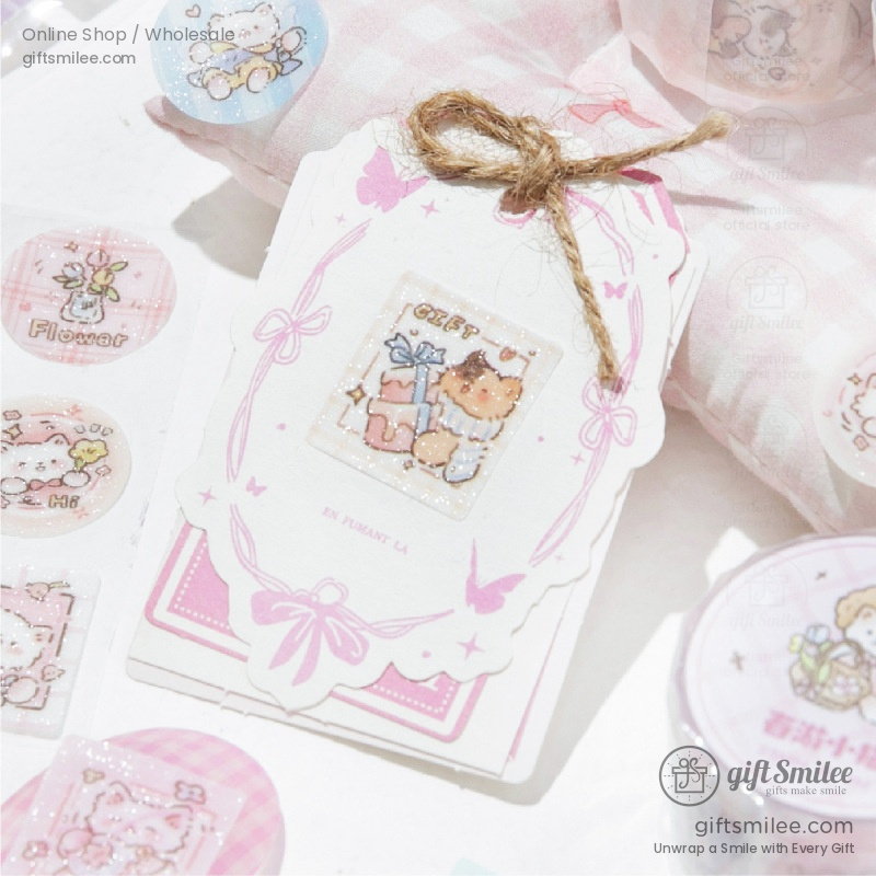 Pastel pink gift tag with glitter accents featuring a cute animal illustration butterfly motifs and a twine loop