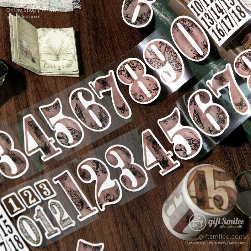 Vintagestyle number stickers with floral and butterfly patterns on translucent tape laid on a wooden surface