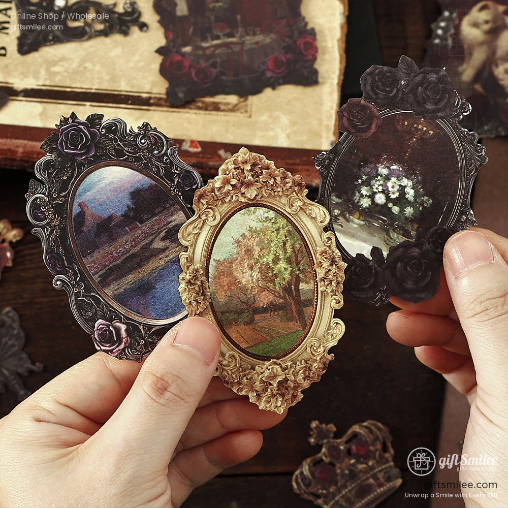 Hand holding ornate Victorian-style vintage frame stickers with floral and gothic designs
