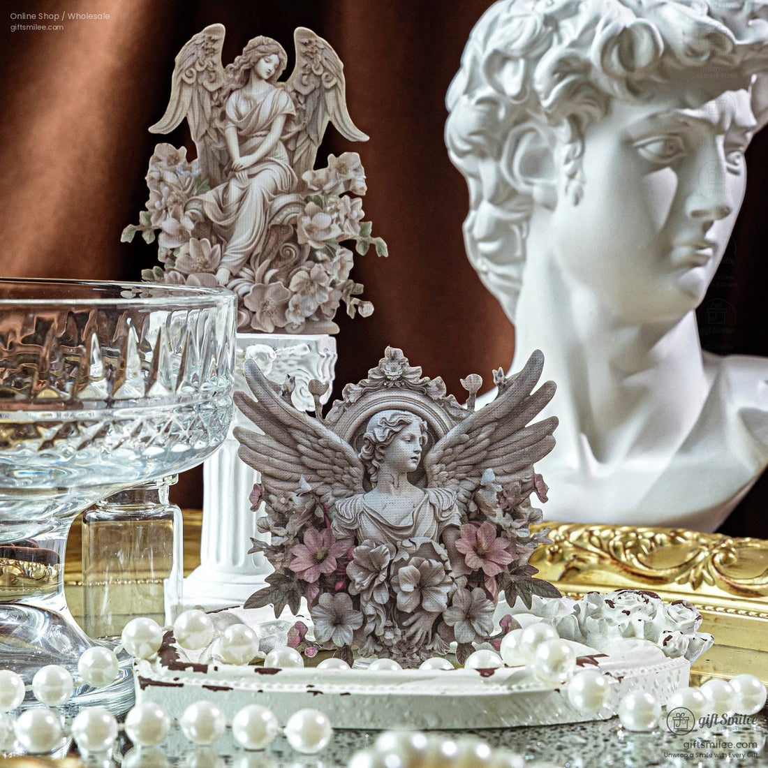 Close-up of vintage gypsum angel statue stickers on a decorative table with pearls and glassware