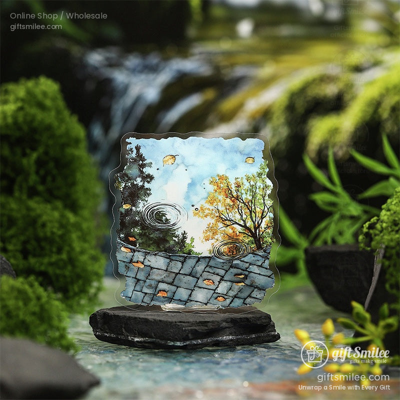 Nature-inspired watercolor sticker featuring a puddle with autumn reflections and golden leaves