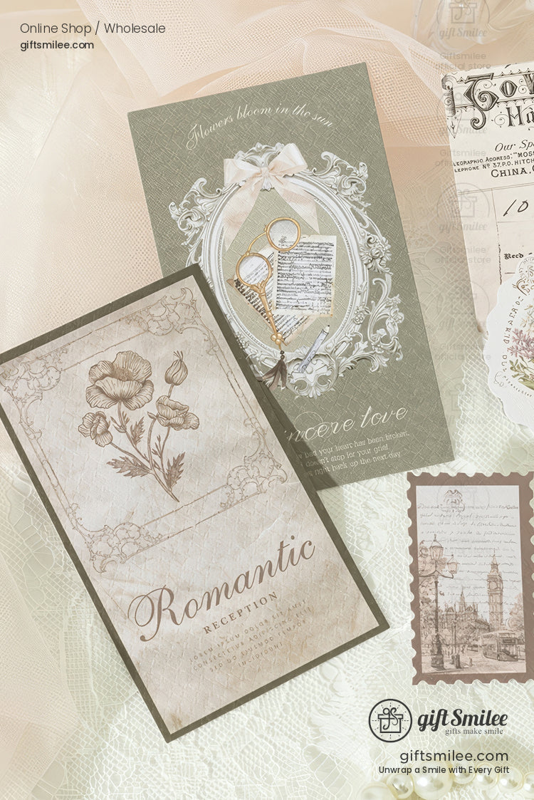 Vintage-style romantic greeting cards and stationery flat lay with floral illustrations, ornate frame, and sepia city stamp on lace background.