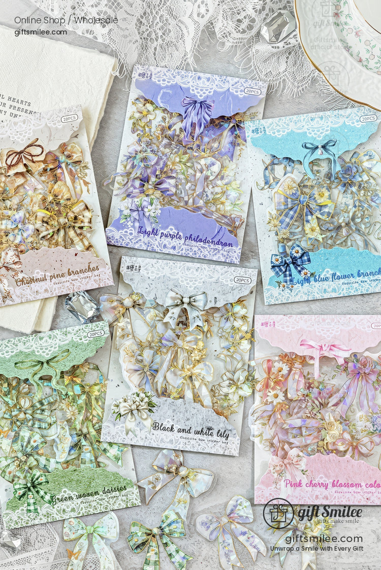 Pastel floral craft sticker sets arranged flat lay, featuring hydrangea, lily, cherry blossom and bow designs on lace-themed packaging.