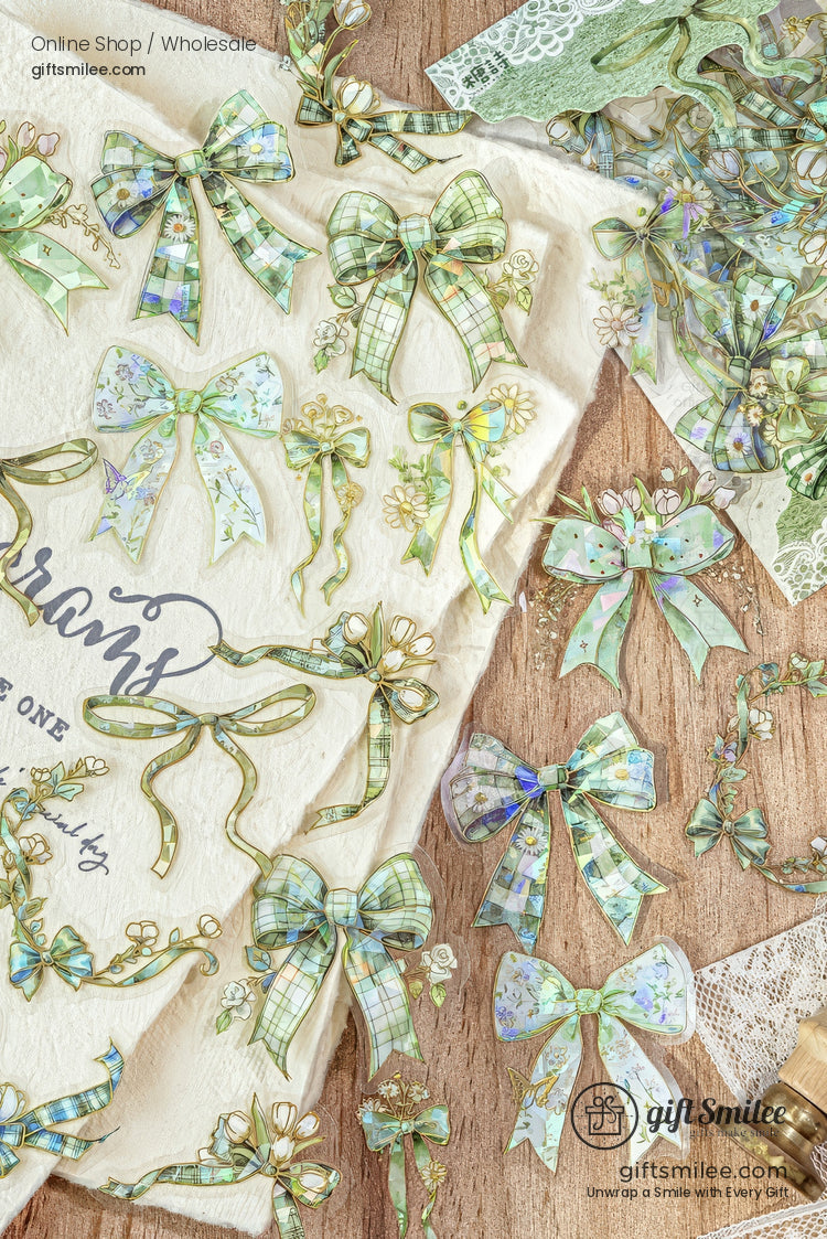 Pastel green and blue floral ribbon bow stickers arranged on a wooden background – decorative stationery for scrapbooking and gifts.