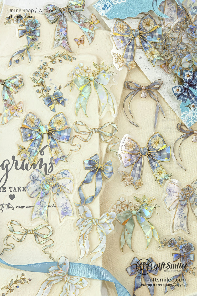 Pastel blue and gold floral ribbon bows and stickers arranged on a cream scrapbook background for crafting and stationery.