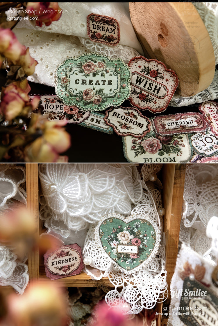 Vintage-style embroidered fabric labels with floral designs and words like “Create,” “Wish,” and “Kindness,” displayed on lace and wooden props for craft and sewing projects.