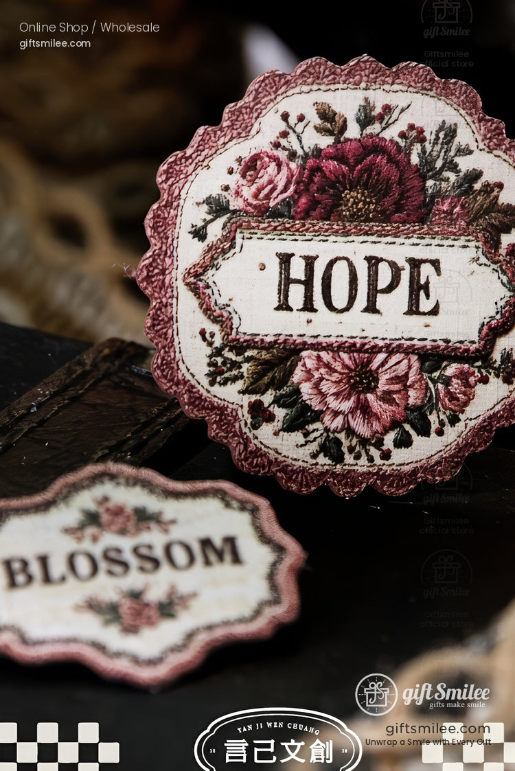Vintage embroidered patch with floral design and the word “HOPE” in pink tones on a scalloped badge.