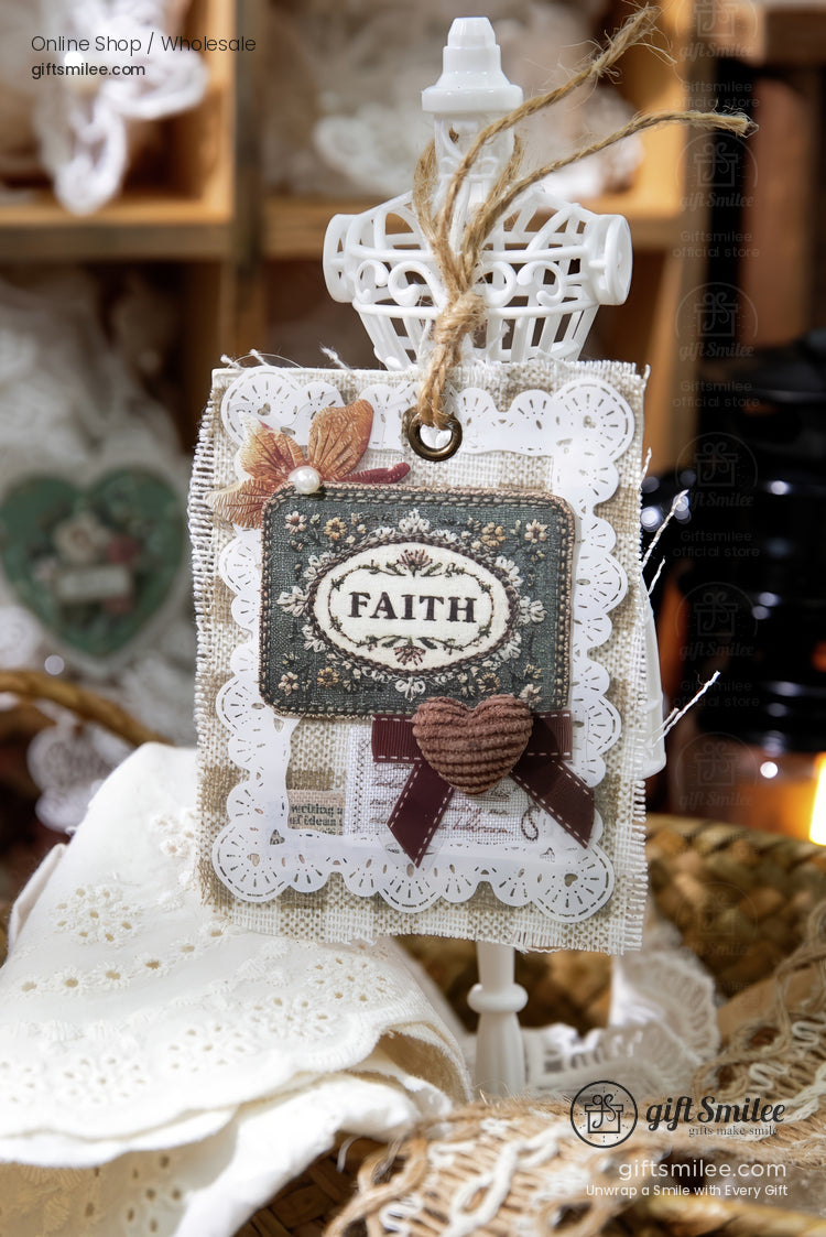 Handmade vintage-style “Faith” tag with lace, burlap, and ribbon on a white dress-form display, rustic craft decor.