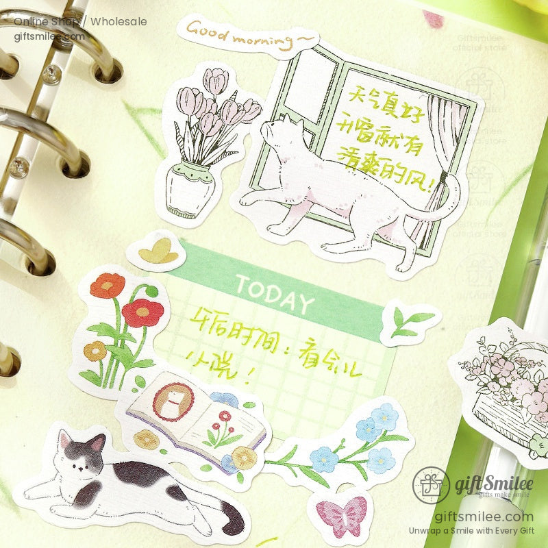 Pasteltoned planner stickers with floral designs lounging cats a book and a window scene on a pale green background