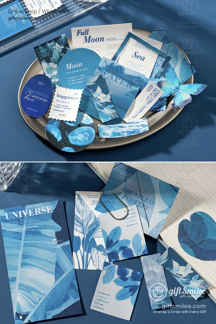 Assorted bluethemed paper stationery with floral butterfly and moon designs on a metallic plate and desk surface