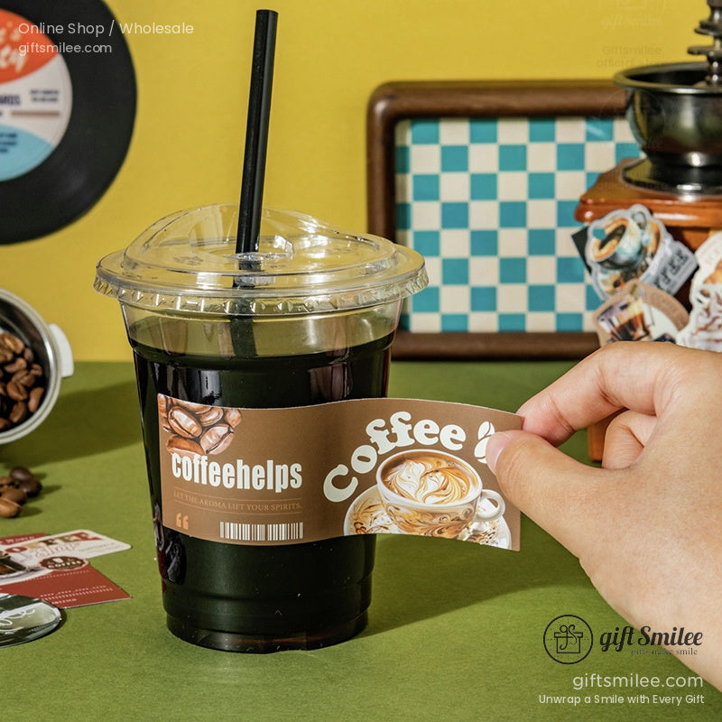 Clear plastic coffee cup with black straw filled with dark espresso brown label featuring coffee beans and latte art
