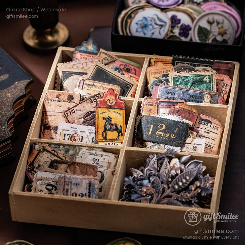 Vintagethemed paper ephemera in a wooden organizer featuring floral cutouts tickets and antiquestyle labels