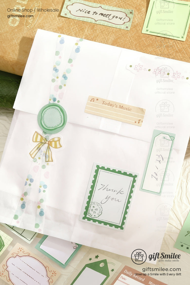 White gift bag with pastel dot ribbon green thankyou card yellow bow and decorative vintagestyle labels