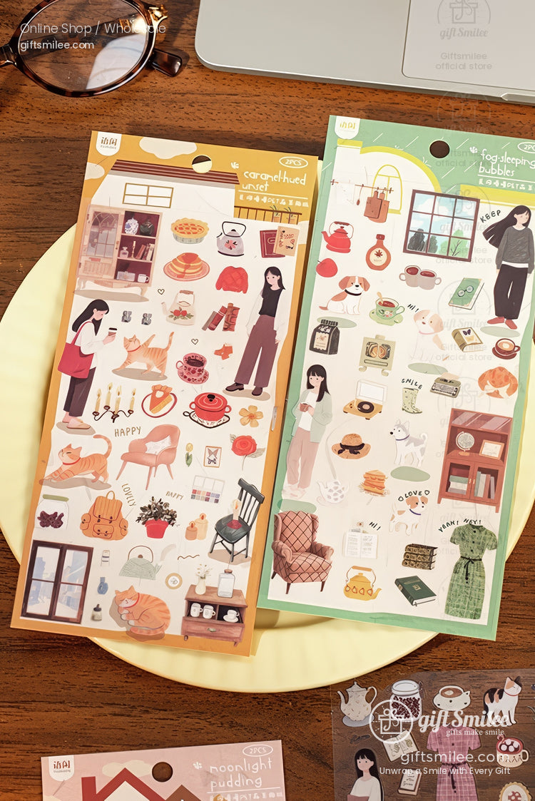 Two sheets of cozythemed stickers with warm orange and green designs featuring pastries books furniture and home decor