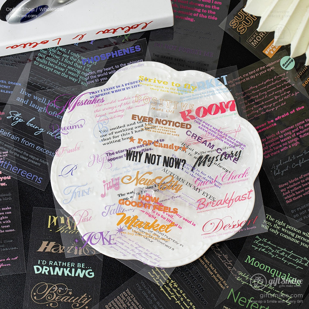 Scalloped white ceramic plate with colorful typography and motivational phrases set on a dark surface with transparent stickers