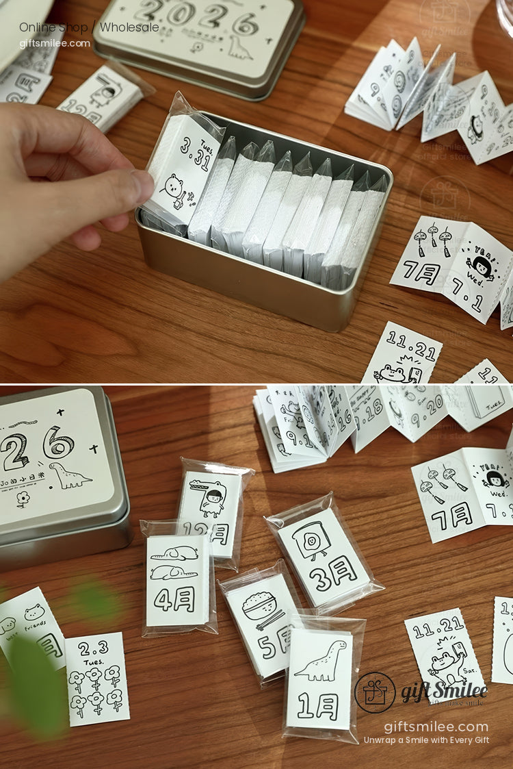 Silver tin box with black and white illustrated calendar cards featuring monthly designs and playful drawings