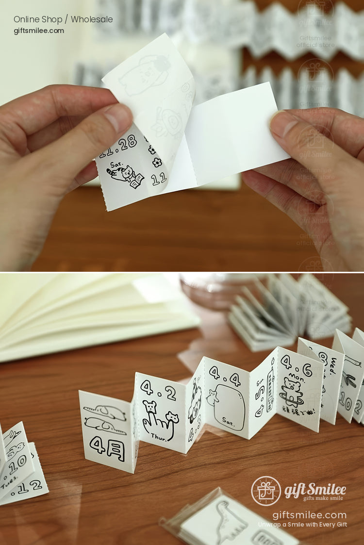 Mini accordionstyle booklet with black handdrawn doodles on white paper laid on a wooden surface