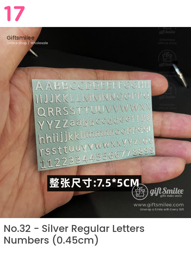 Silver metal stencil with uppercase lowercase letters and numbers measuring 75x5 cm held in a hand