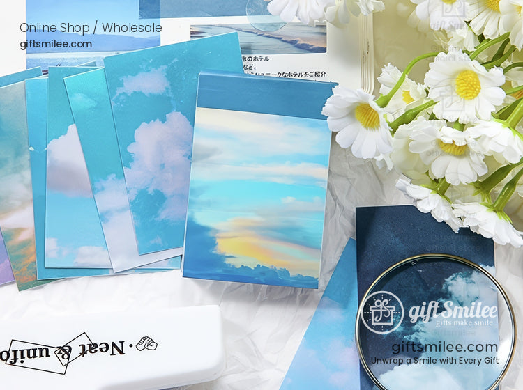 Skythemed stationery with vibrant cloud prints pastel blue tones and decorative elements alongside white daisies