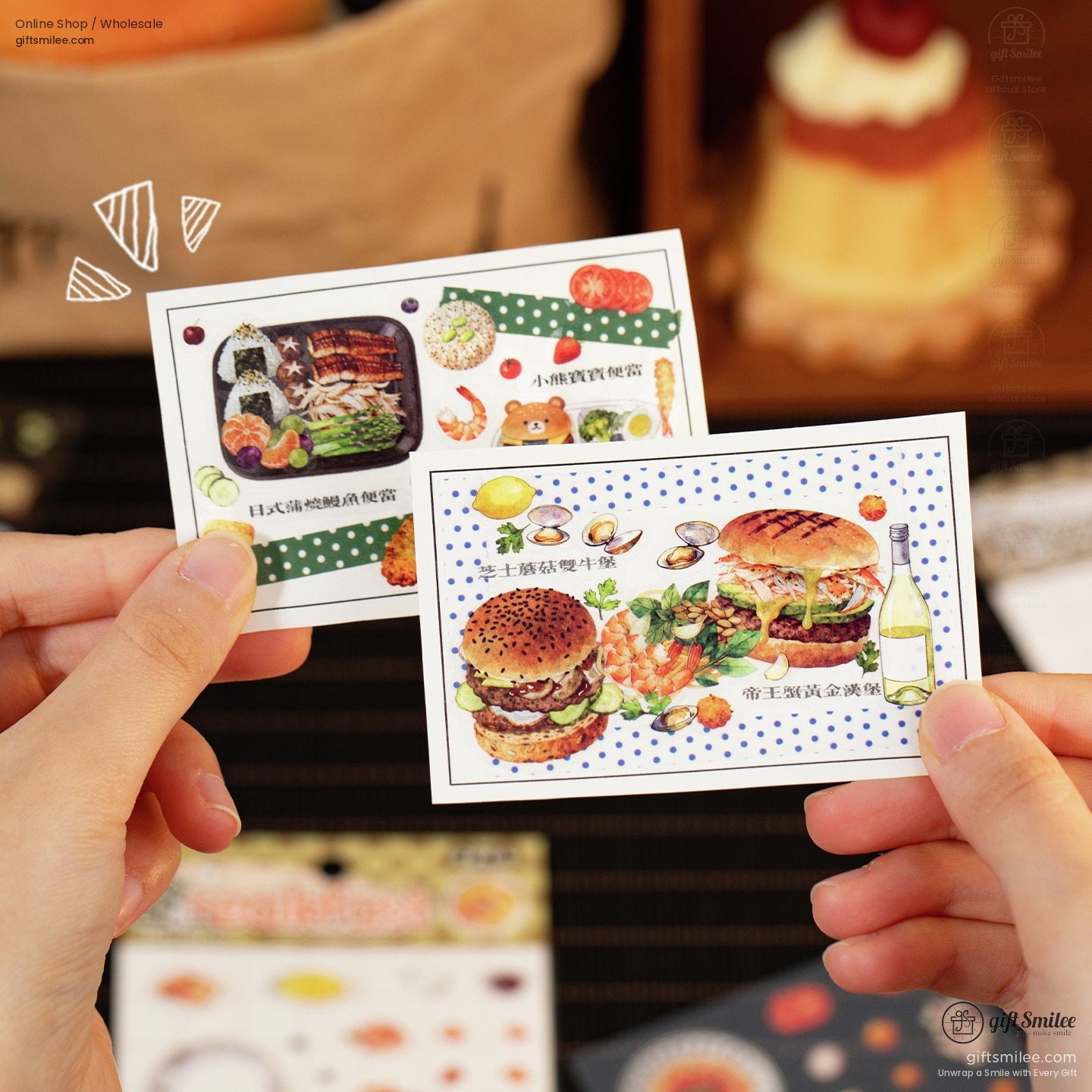 Hand holding colorful illustrated recipe cards with burger seafood and bento designs accented by dotted backgrounds