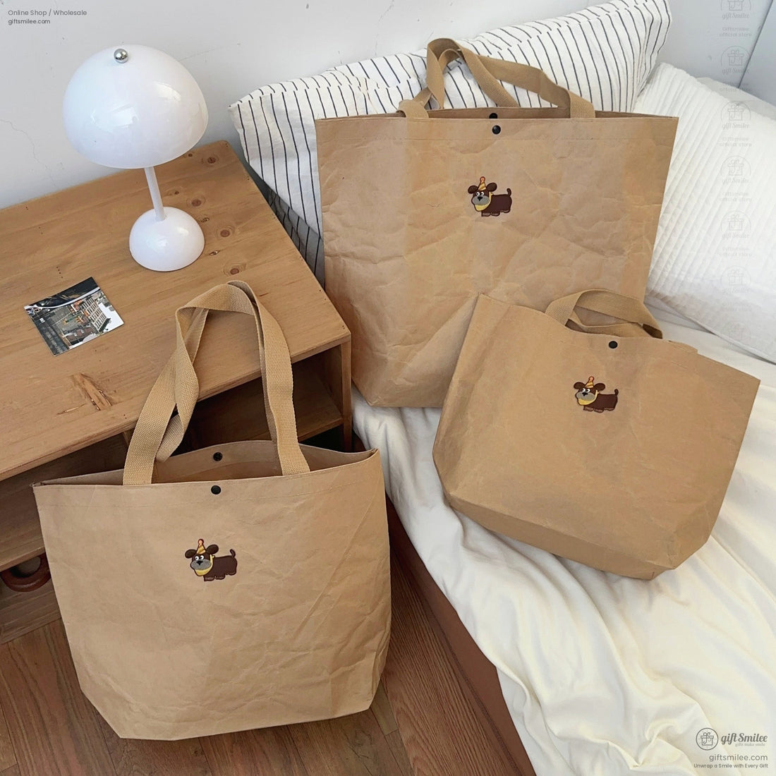 Set of three brown kraft paperstyle tote bags with sturdy beige straps and a cartoon dog print embellishment