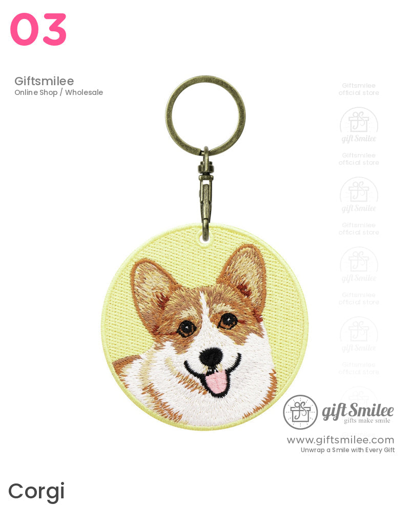 Round yellow fabric keychain with embroidered corgi face detailed brown and white fur cheerful expression and metal clasp