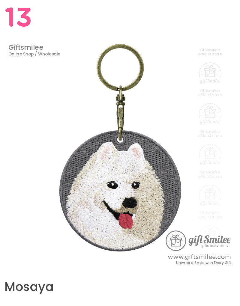Gray round keychain with embroidered white Samoyed dog face pink tongue detail and antique brass metal clasp