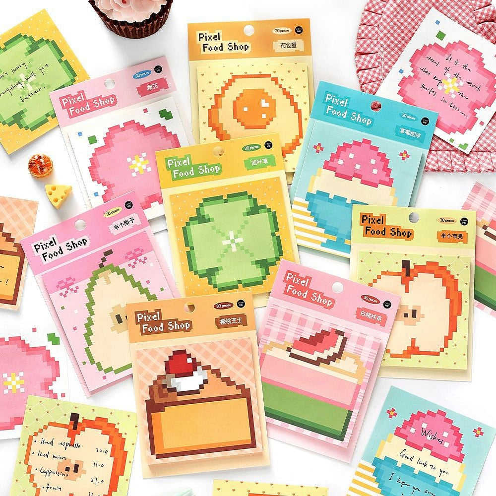 Colorful pixel art sticky notes with fruit and dessert designs in pastel packaging ideal for creative stationery